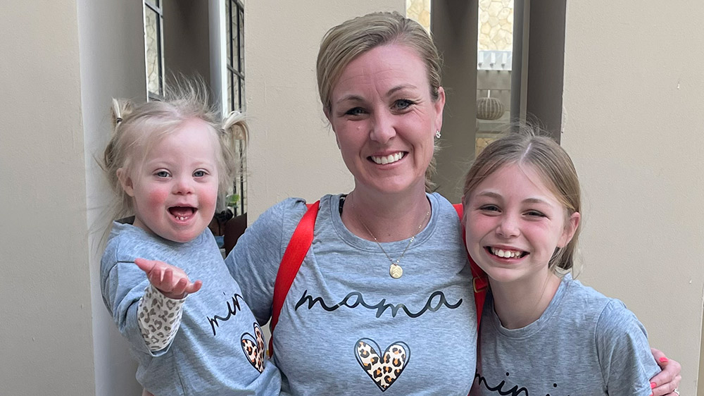 mom smiling with two daughters