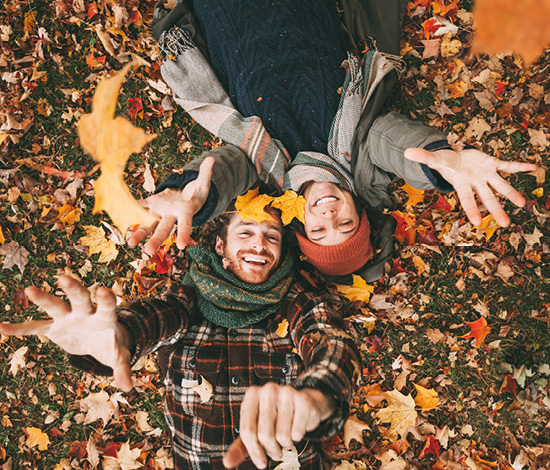 Two people laying in leaves